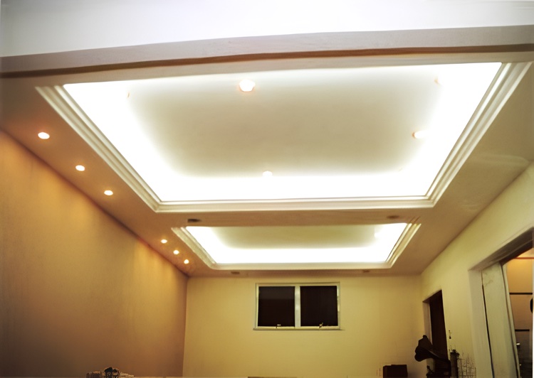 Sala com forro de gesso rebaixado e iluminação indireta, com luminárias embutidas